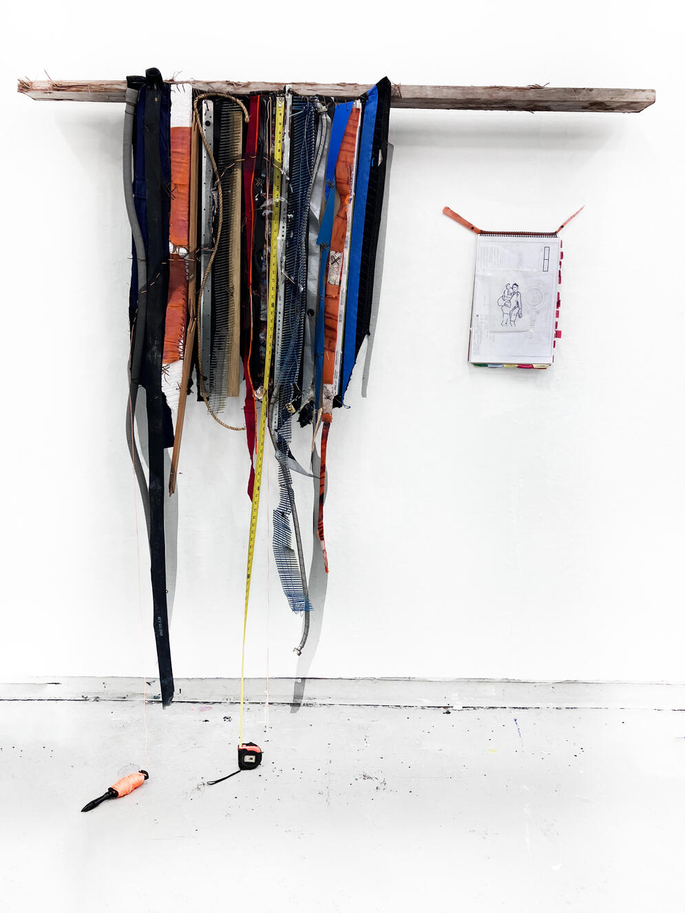 "Rest in Power" (with Human Drawings Artifact), 2024, Tape measure, inner tube, washer hose, moving blanket, plastic 55 gal drum, wood, nails, tarp, window screen, shop rag, sinew, metal, traffic cone, uniform, found objects, 8' × 8' × 8".